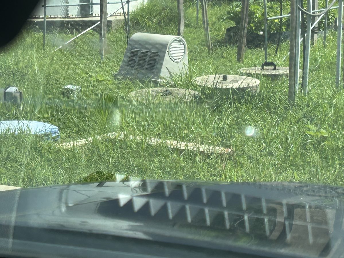 Neglected aerobic septic system with overgrown vegetation requiring repair service by Harris County Septic